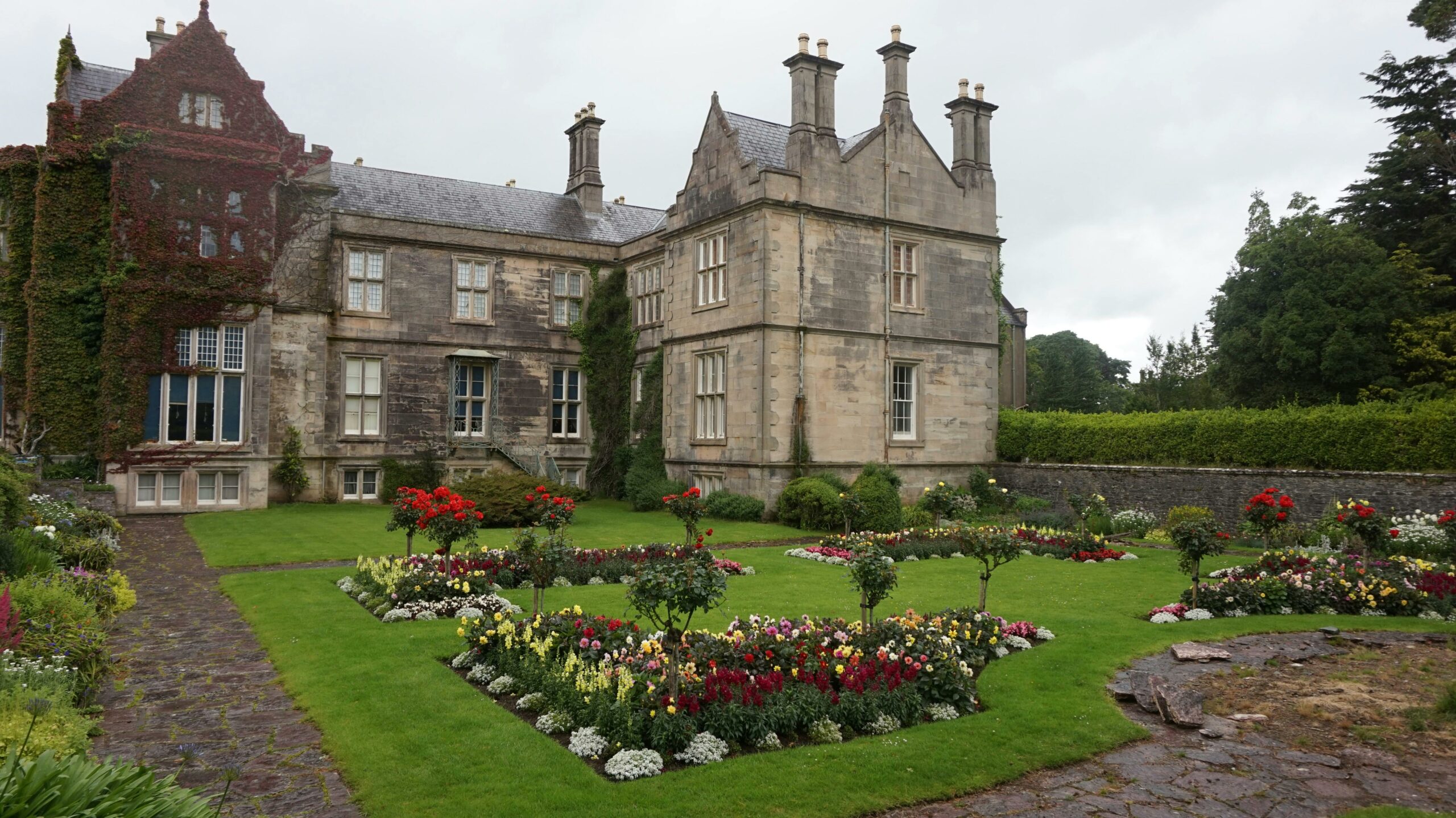 Beautiful view of the historic Muckross House surrounded by lush, manicured gardens.